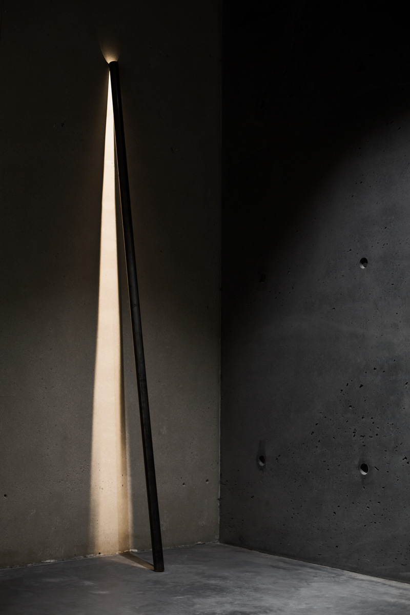 A photograph of Silhouet Lighting Tube on a concrete wall at ETQ store by Poppyonto