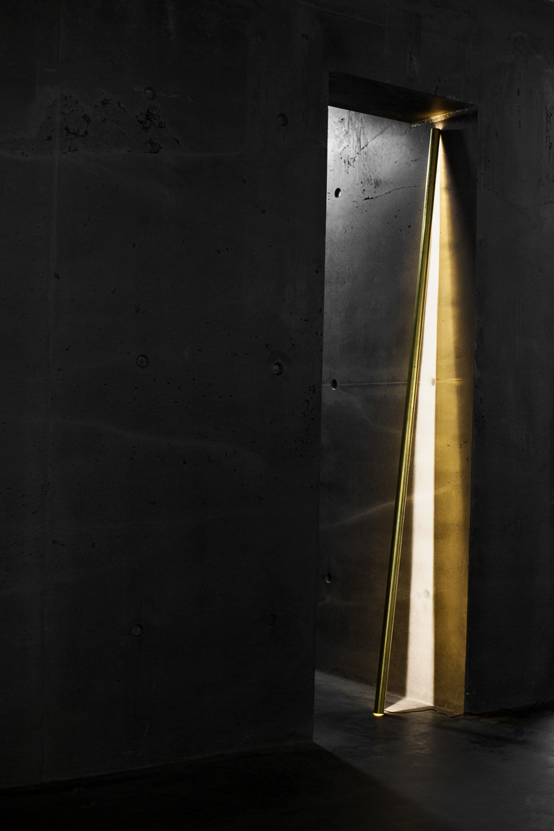 A photograph of Silhouet Lighting Tube in a concrete doorway at ETQ Store Amsterdam by Poppyonto